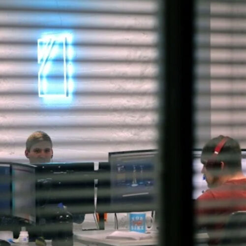 An image of an office, taken through a set of blinds