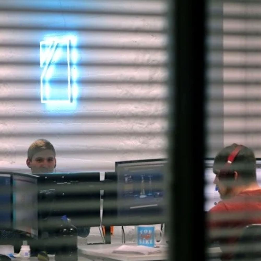 An image of an office, taken through a set of blinds, looking at our web design team