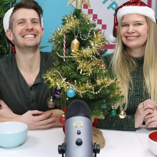 Rob and Amy wearing Santa hats, next to a small Christmas tree