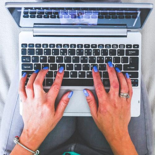 A person typing on a laptop from above