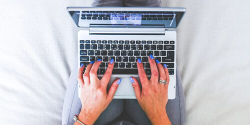A person typing on a laptop from above