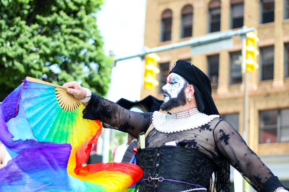 Drag performer waving a pride fan