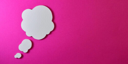 A paper thought bubble on a pink background