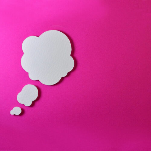 A paper thought bubble on a pink background