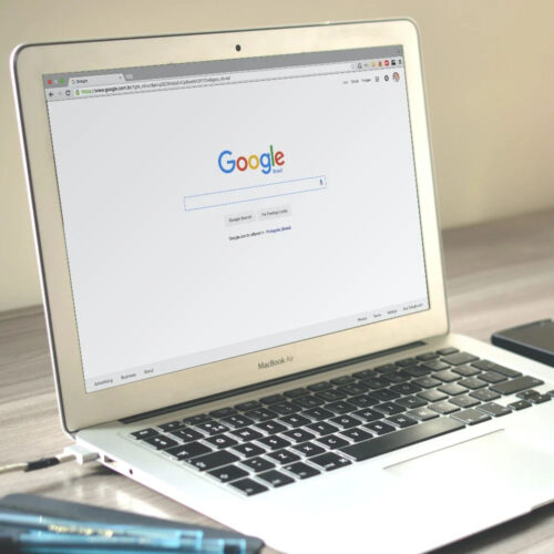 a laptop showing the google home page on screen