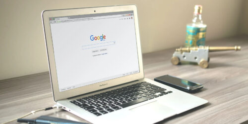 a laptop showing the google home page on screen