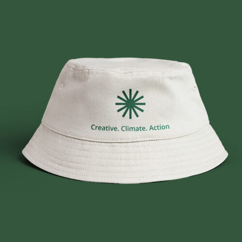 A white bucket hat with green background with the Climate. Creative. Action logo