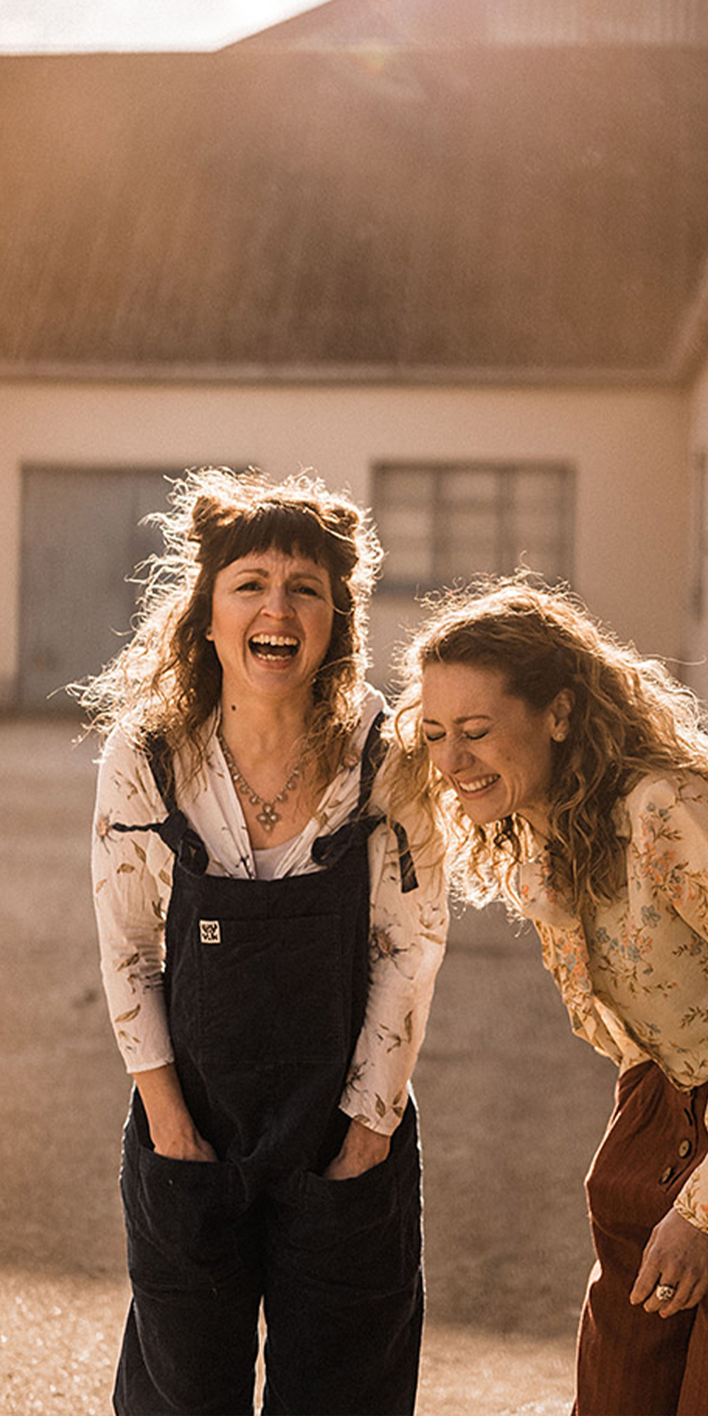 Two people in dungarees smiling and laughing