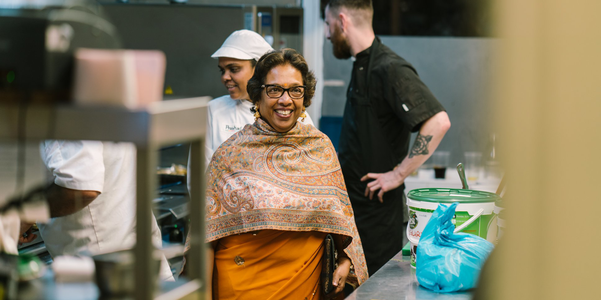 Kaushy Patel dressed up in a kitchen smiling