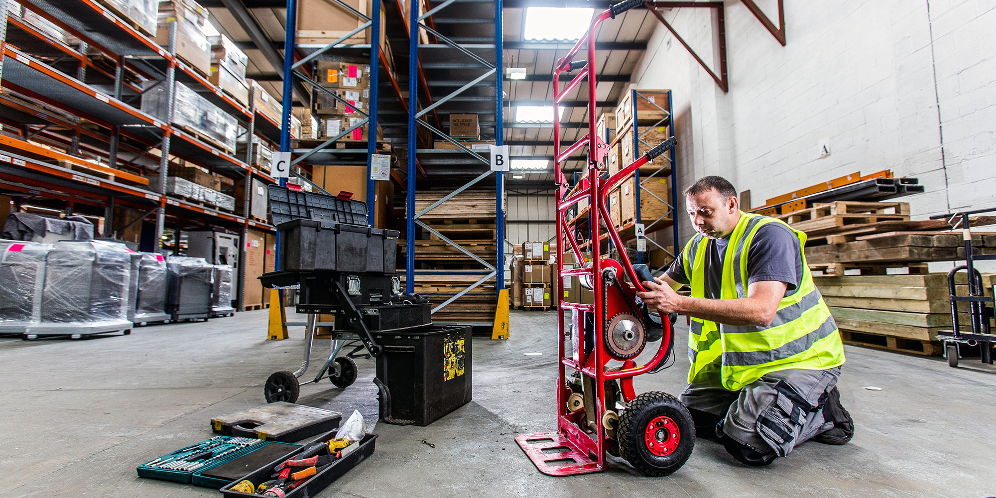 A workman in a high viz jacket working on a trolly