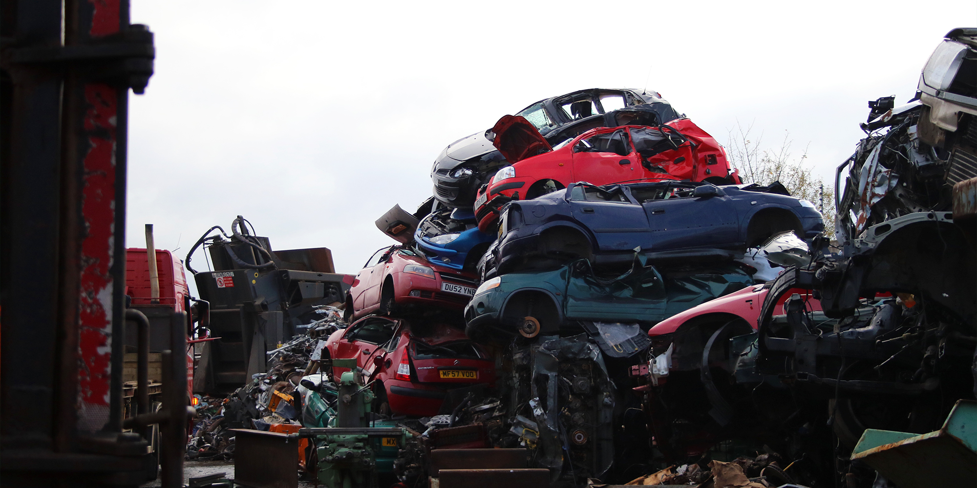 A pile of scrap cars in a scrapyard