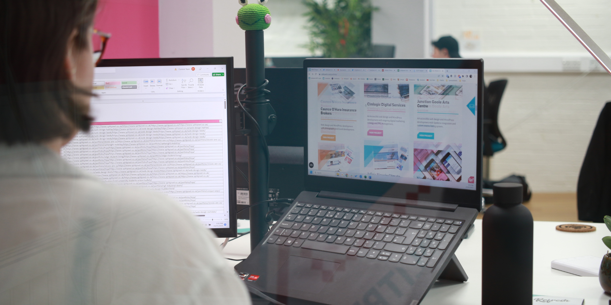 A person working on a computer and a laptop