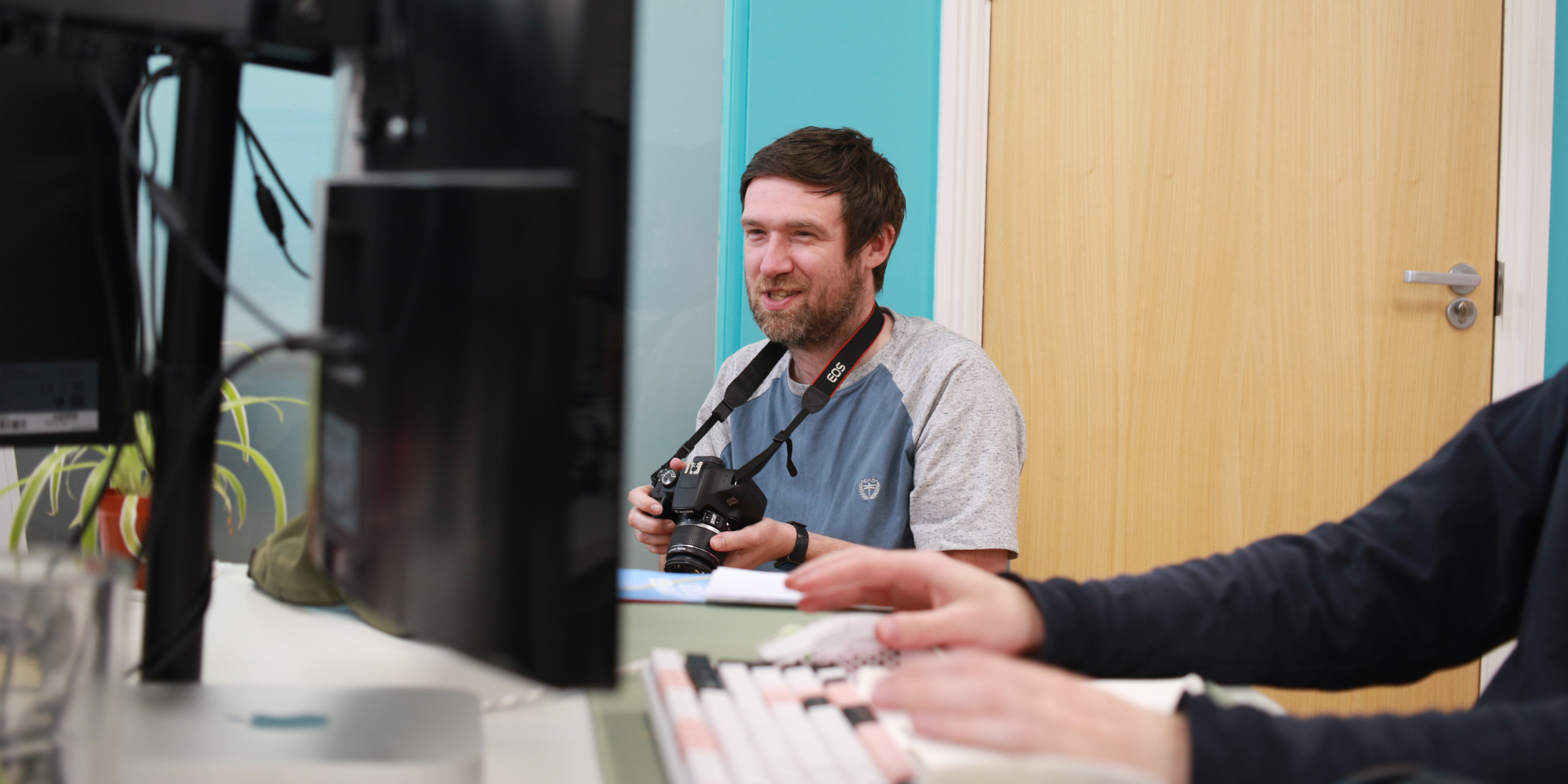 Greg holding a camera and smiling