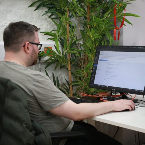 Image of a man sat at a desk working on a computer