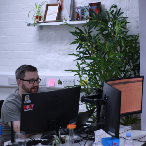 A man wearing glasses looking at a computer screen