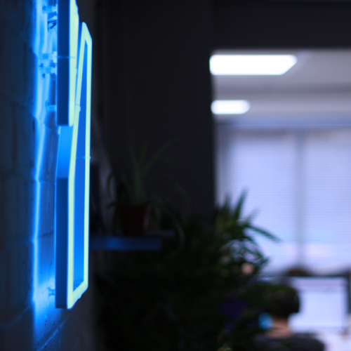 The Splitpixel logo in neon lights, lit up in blue