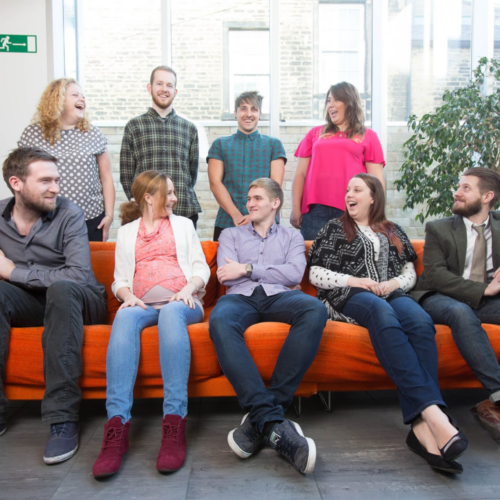 Splitpixel employees in 2014 sat on an orange sofa