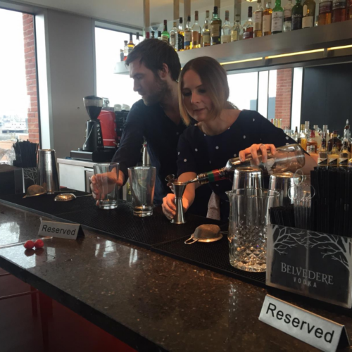 Charlie and Greg making cocktails behind a bar in 2016